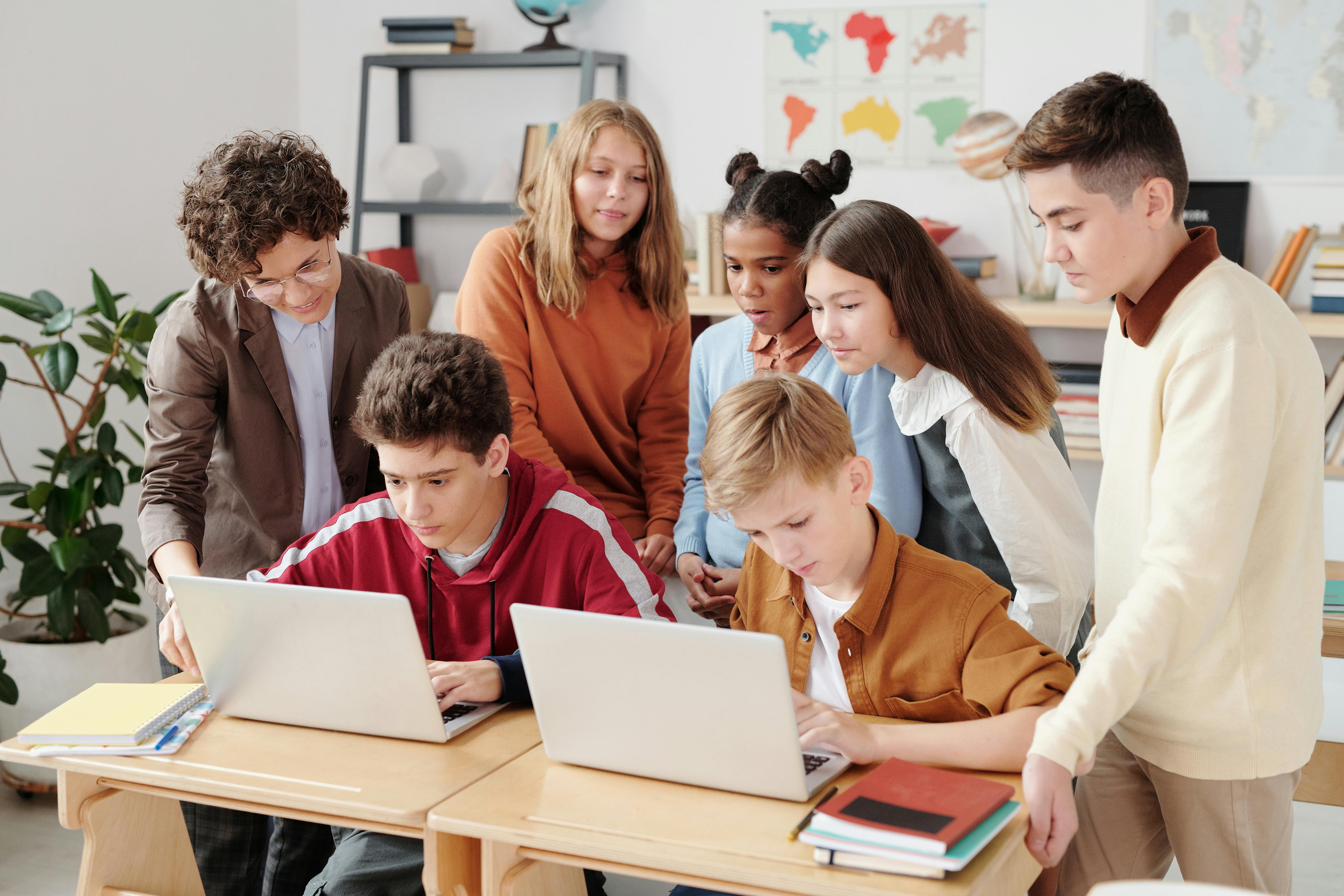 Group of students gathering around and using OnePoint Student Information system to look at class schedules.